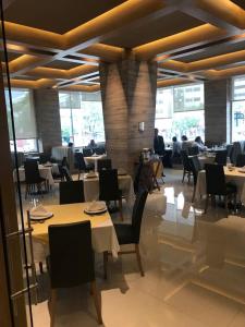 um restaurante com mesas e cadeiras e pessoas sentadas a mesas em Lisboa Hotel em Cidade do México