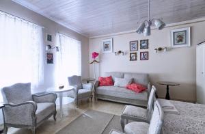 a living room with a couch and chairs and a table at Ribizli Vintage Vendégház in Parád