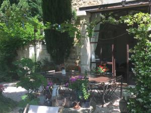 un patio con tavolo, sedie e piante di Mas de Rey a Rognonas