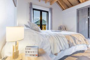 a white bedroom with a bed with a sign on it at Les Edelweiss Mont-Blanc - Gîte Classé 3 Etoiles in Passy