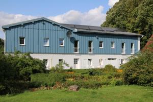 una casa azul y blanca con patio en Ferienscheune Juhlsgaard en Husby