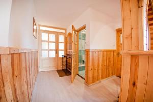 ツァルナ・グラにあるWynajem Pokoi ,,Góry Tatry Wypoczynek "Paweł Kuczyńskiのウッドフロアの廊下、木製の壁の客室を提供しています。