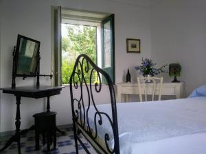a bedroom with a bed and a desk and a window at Nunziata in Mineo