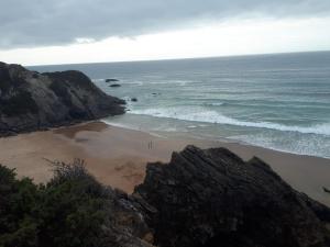 a beach with people on the sand and the ocean at Sol Mar in Odeceixe