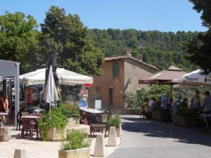 a patio with tables and umbrellas and a building at Gîte LA BOUSCARLE in Moissac-Bellevue