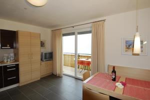 a kitchen with a dining table and a view of the ocean at Der Blaue Reiter in Schenna