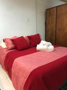 uma grande cama vermelha com duas toalhas em Apartaestudio en Chia em Chía