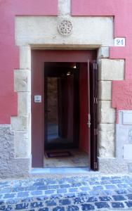 a doorway to a building with a red and pink wall at Ca La Tambona in Sant Feliu de Pallerols
