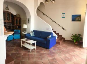 a living room with a blue couch and stairs at Little Flower in Positano