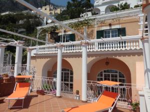 
a patio area with chairs, tables and umbrellas at Little Flower in Positano
