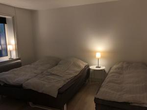 2 camas en un dormitorio con una lámpara en una mesa en Hel lejlighed Thisted Midtby, en Thisted