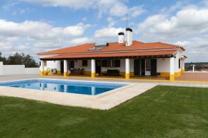 a villa with a swimming pool in front of a house at Villa do Outeiro in Figueira e Barros
