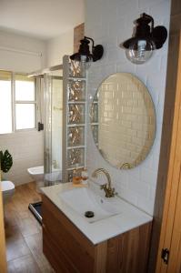 a bathroom with a sink and a mirror and a toilet at Romantic apartment with free parking in Seville