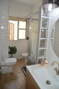 a bathroom with a toilet and a sink and a mirror at Romantic apartment with free parking in Seville