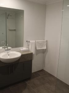 ein Bad mit einem Waschbecken und einem Spiegel in der Unterkunft Club Mulwala Resort in Mulwala