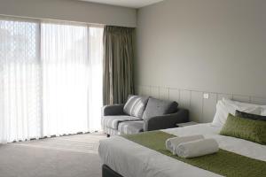 a hotel room with a bed and a couch at Club Mulwala Resort in Mulwala