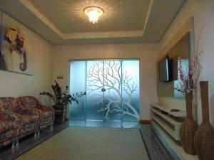 a living room with a glass door with a tree in it at Golden View Hotel in Capitão Leônidas Marques