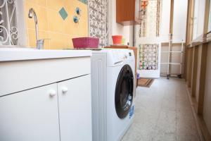 a white washing machine in a kitchen with a sink at Maman Suite, city center near Molo Beverello in Naples
