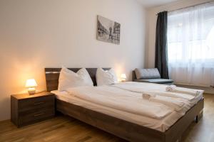 a bedroom with a bed and a chair and a window at Minihotel Graz Apartments in Graz