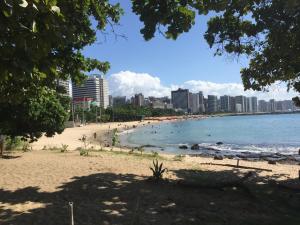a beach in a city with people swimming in the water at Apartamento New Life in Fortaleza