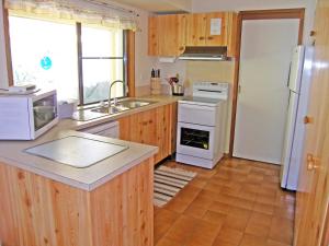 a kitchen with wooden cabinets and a white refrigerator at WARR4C - Home Away in Myola