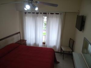 a bedroom with a red bed and a window at Hotel Neptuno in Miramar +22 photos