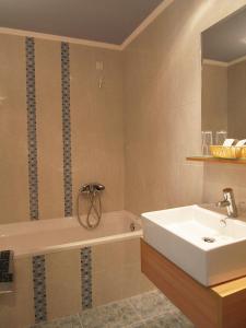 a bathroom with a tub and a sink at Kitro Beach Hotel in Agios Nikolaos