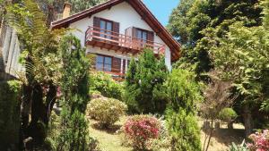 a house on the side of a hill with trees at Chalés Lauterbrunnen in Monte Verde
