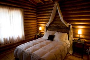 a bedroom with a bed in a log cabin at Complejo Rural Puerto Peñas in Aroche