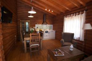 a living room with a kitchen and a dining room table at Complejo Rural Puerto Peñas in Aroche