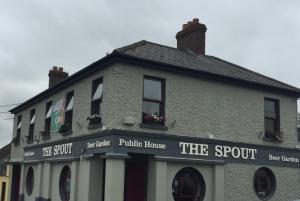 un edificio con un cartello che legge il pub abusivo di The Rooms at The Spout a Kilcullen