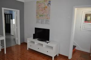 a living room with a tv on a white cabinet at A Casa do Mestre in Évora