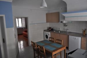 una cucina con tavolo, lavandino e piano cottura di A Casa do Mestre a Évora