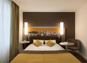 a bedroom with a large bed with yellow pillows at Mercure Avignon Centre Palais des Papes in Avignon