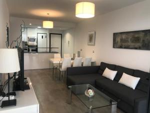 a living room with a couch and a table at Infinity View Paradise Apartment in Arenales del Sol
