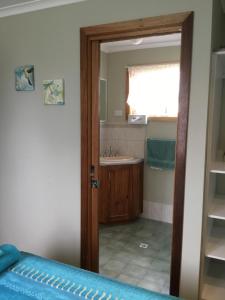 a bathroom with a door open to a bathroom with a sink at Millicent Lakeside Caravan Park in Millicent
