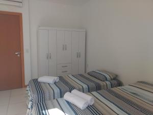 two beds in a room with towels on them at Ap 2/4 na Reserva Imbassaí in Imbassai