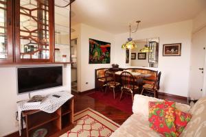 a living room with a couch and a dining room at Apartamento Vista para as Montanhas in Campos do Jordão