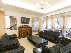 sala de estar con 2 sofás y TV en Guanziling Lin Kuei Yuan Hot Spring Resort, en Baihe