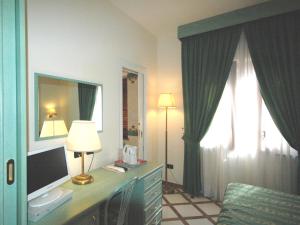 a bedroom with a desk with a lamp and a mirror at Residence Villaggio Verde in Sorrento