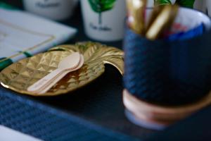 a gold plate with a spoon on top of a table at Tea Gardens Hotel in Tea Gardens