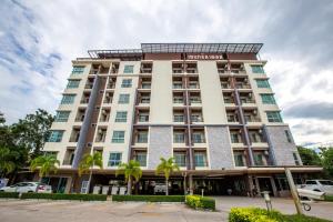 a hotel building with palm trees in front of it at Central Place Serviced Apartment in Chon Buri