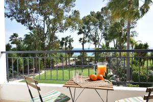 a table with oranges and a glass of orange juice on a balcony at Deluxe First Line Villa in Pervolia