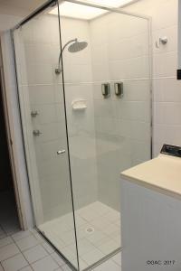 a shower with a glass door in a bathroom at Mollymook Cove Apartments in Mollymook