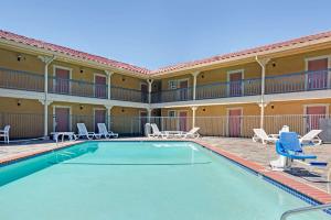 a pool at a hotel with chairs and a resort at Days Inn by Wyndham San Jose Convention Center in San Jose