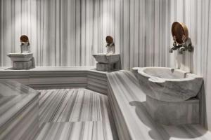 a bathroom with two toilets and a sink and a tub at Ramada By Wyndham İstanbul Taksim in Istanbul