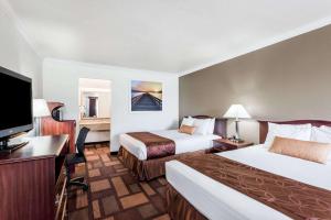 a hotel room with two beds and a flat screen tv at Days Inn & Suites by Wyndham Lodi in Lodi