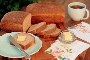 a wooden table with bread and a cup of coffee at Catalina`s Inn family room in Panglao Island