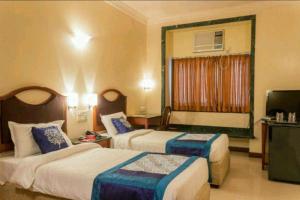 Postel nebo postele na pokoji v ubytování Strand Hotel, Colaba
