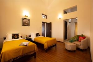 a hotel room with two beds and a chair at The Xanadu Birkenhead in Kodaikānāl